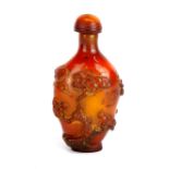 A relief decorated amber coloured snuff bottle, H. 8.5cm.