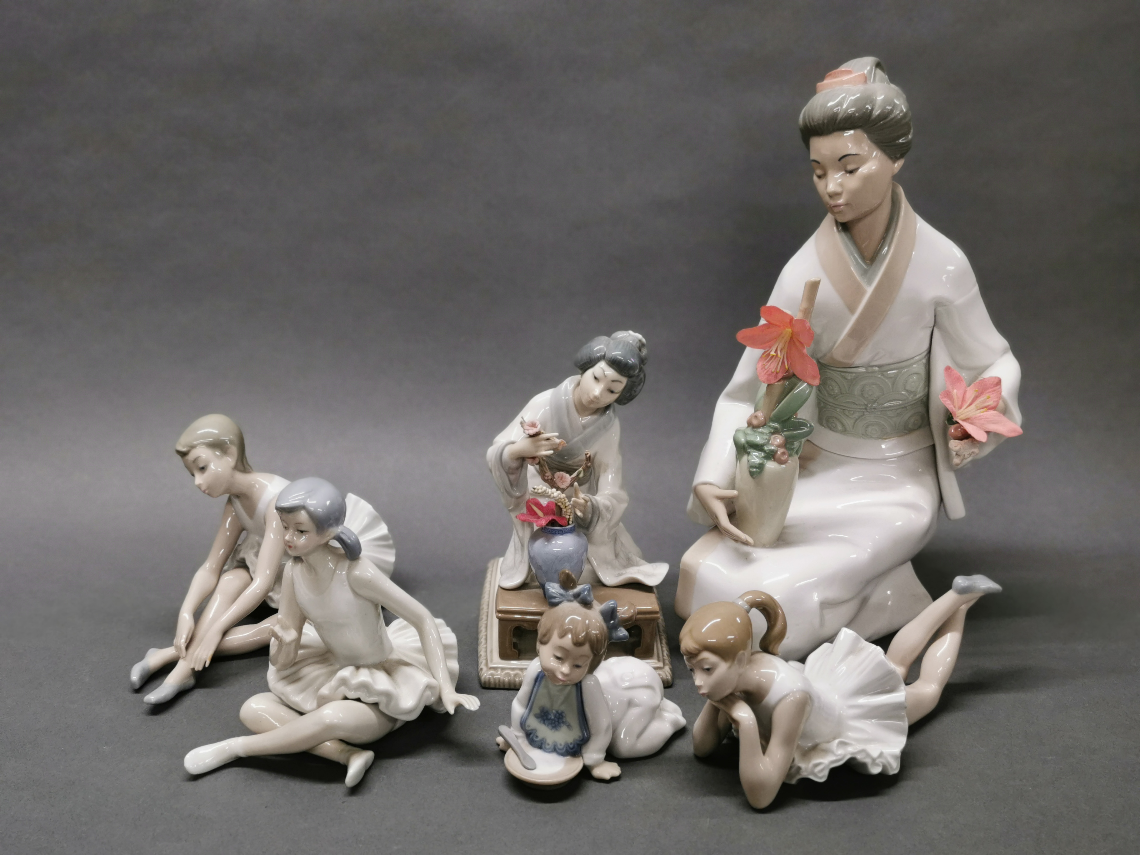 A Lladro figure of a Geisha with a vase of flowers, H. 19cm, together with a large Nao porcelain