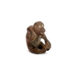 A signed fruitwood Netsuke of a monkey with inset glass eyes, H. 4.5cm.