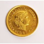 A gold Swiss 1969 ten franc coin.