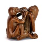 A signed carve fruitwood erotic netsuke of a woman with a monkey.