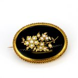 A yellow metal (tested 9ct gold) onyx and seed pearl set mourning brooch, L. 5cm.