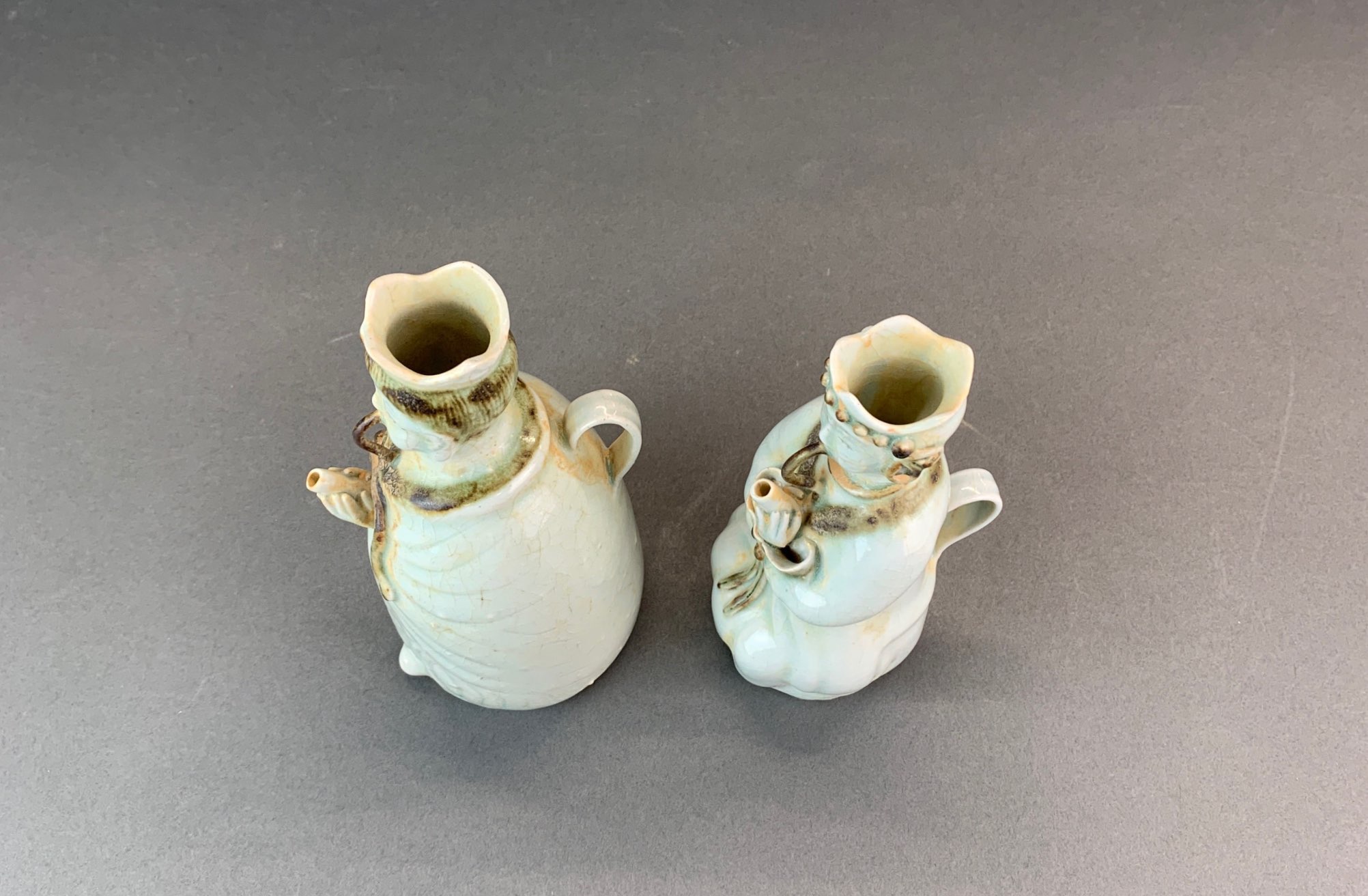 A pair of Chinese celadon glazed porcelain figural wine jugs, H. 19cm. - Image 4 of 4