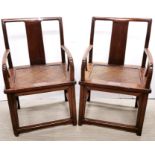 A pair of Chinese hardwood armchairs with cane seats. (one seat slightly A/F).