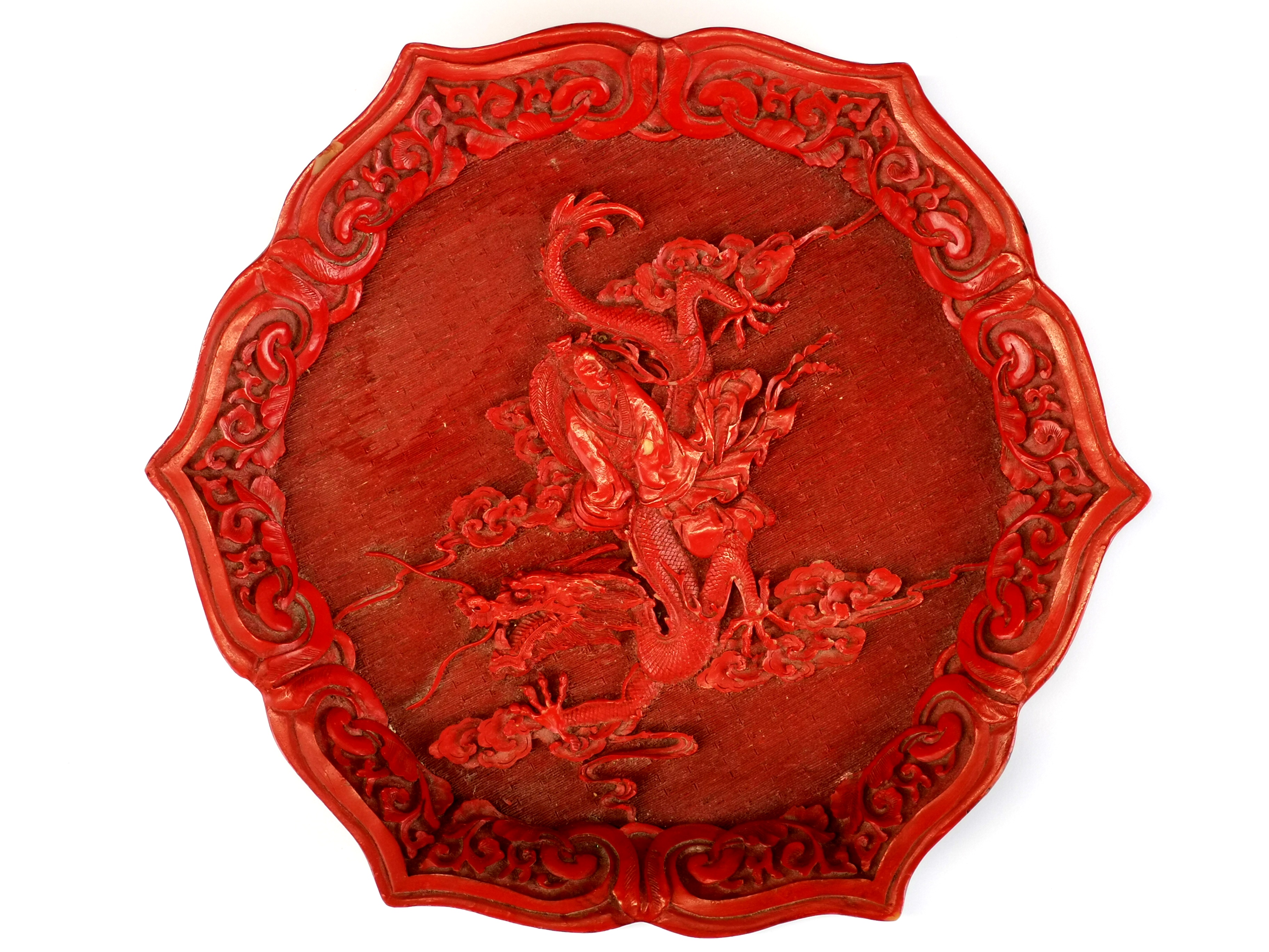 A Chinese relief decorated Cinnabar style plate, Dia. 22cm.