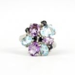 A 925 silver ring set with oval cut blue topaz, amethysts and sapphires, (O).