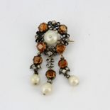 An antique yellow and white metal brooch/pendant set with natural pearls and hessonite garnets, L.