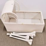 A vintage loom style baby's cot with legs.