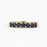 A hallmarked 9ct yellow gold ring set with round cut sapphires, (N).