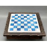 A polished onyx chess board inset into a wooden frame, 45 x 45cm, with an onyx chess set, king H.