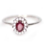 A 925 silver cluster ring set with an oval cut ruby and white stones, (Q).