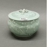 A Chinese relief decorated celadon glazed porcelain bowl and cover, dia. 20cm, H. 14cm.