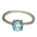 A 925 silver ring set with round cut blue topaz and white stones, (R.5).