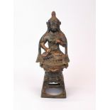A Tibetan painted and gilt cast bronze figure of a seated Buddhist goddess, H. 24cm.