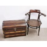 A bentwood armchair and a dome topped trunk.