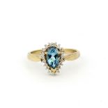 A hallmarked 9ct yellow gold ring set with a pear cut blue topaz surrounded by diamonds, (S.5).