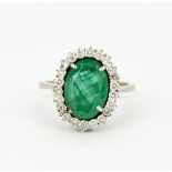 A hallmarked 18ct yellow gold cluster ring set with a large oval cut emerald, L. 1.5cm. surrounded