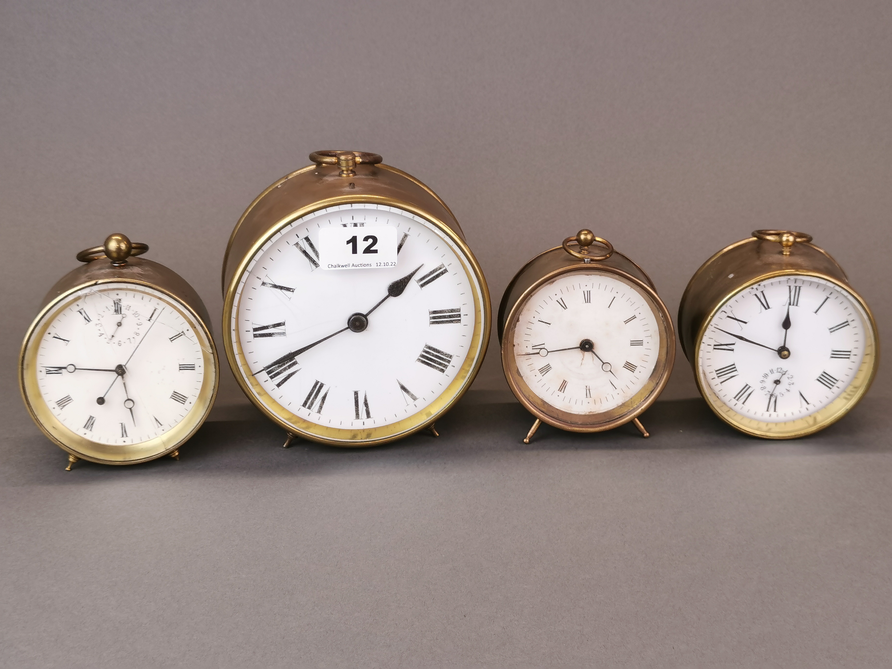 A group of four brass alarm clocks, largest Dia. 14cm.