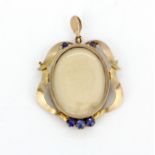 A 9ct yellow gold locket pendant set with blue garnets, L. 3.5cm.
