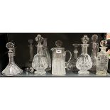 A cut crystal jug and a group of cut crystal decanters.