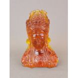 An attractive amber coloured resin bust of a Buddhist goddess, H. 19cm.