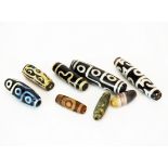 A group of eight Tibetan Dzi beads, longest 6cm.