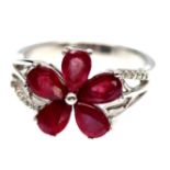 A flower shaped ring set with pear cut rubies and white stones, (L.5).