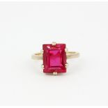 A 9ct yellow gold ring set with a large bevel cut synthetic ruby, (H.5).