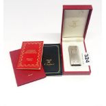 A boxed Must de Cartier stainless steel and gilt lighter.