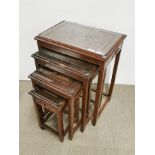 A nest of four Oriental carved teak side tables with plate glass tops, largest 50 x 36 x 67cm.
