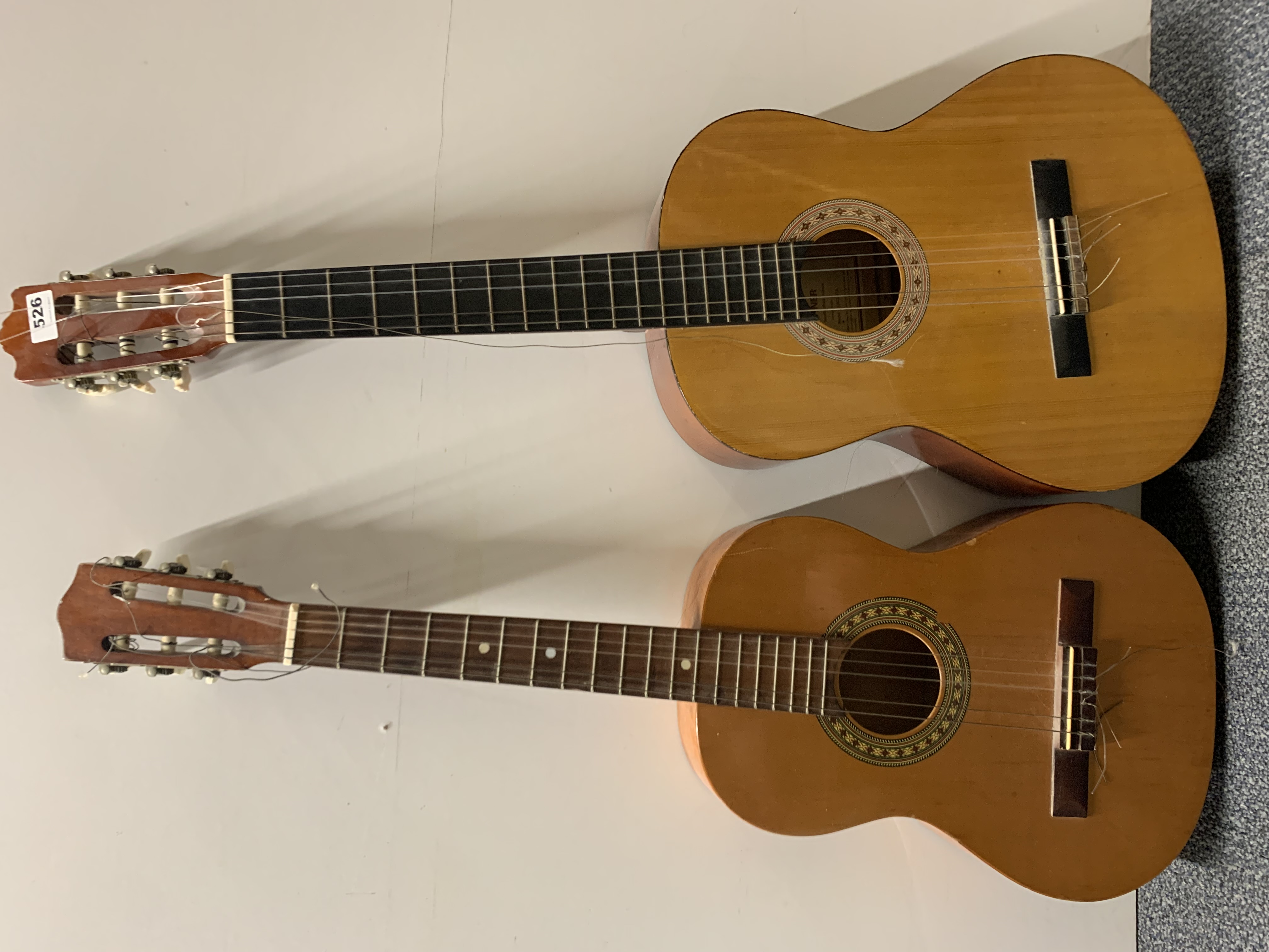 An acoustic guitar and a half size guitar.