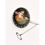 An early 20th century white metal mounted hand painted porcelain brooch with photograph in the