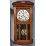 A 1920's mahogany cased wall clock, H. 72cm, appears to be in working order.