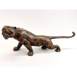 A Japanese bronzed cast metal figure of a tiger with glass eyes, L. 54cm.