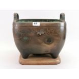 An early 20th century silver inlaid Oriental bronze censer on a wooden base, 33 x 33 x 32cm.