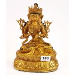 A Tibetan gilt bronze figure of a seated Tara with hand painted face, H. 26cm.