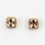 A pair of 18ct rose gold stud earrings each set with a cushion cut morganite surrounded by diamonds,