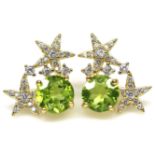 A gold on 925 silver star earrings set with round cut peridots and white stones, L. 1.8cm.
