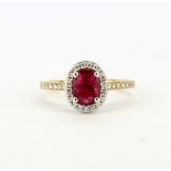 A hallmarked 18ct yellow gold ring set with an oval cut ruby, approx. 1.16ct, surrounded by diamonds