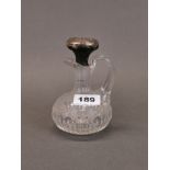 A cut crystal jug with a sterling silver covered stopper, H. 14cm.