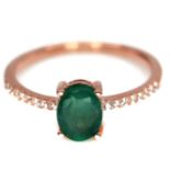 A rose gold 925 silver solitaire ring set with an oval cut emerald and white stones, (O.5).