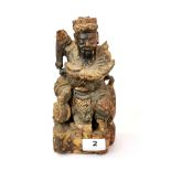 A 19th century Chinese carved wooden figure seated on a mythical animal, H. 23cm.