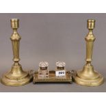 A Victorian brass and cut glass inkwell, W. 21cm, together with a pair of brass candlesticks.