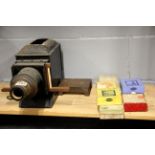 A 19th century lantern slide projector with five boxes of good glass slides, including comical