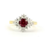 An 18ct yellow gold ring set with a round cut ruby, approx. 0.79ct, surrounded by brilliant cut