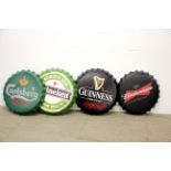 A group of four large metal beer advertising bottle tops, Dia. 40cm.