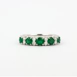 A 950 platinum half eternity ring set with round cut emeralds and brilliant cut diamonds, (M).