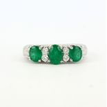 A 950 platinum ring set with oval cut emeralds, approx. 1.13ct total, and brilliant cut diamonds, (