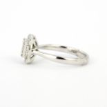 A hallmarked 18ct white gold ring set with baguette and round brilliant cut diamonds, (N).