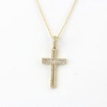 An 18ct yellow gold diamond set cross pendant on an 18ct yellow gold chain, L. 46cm.